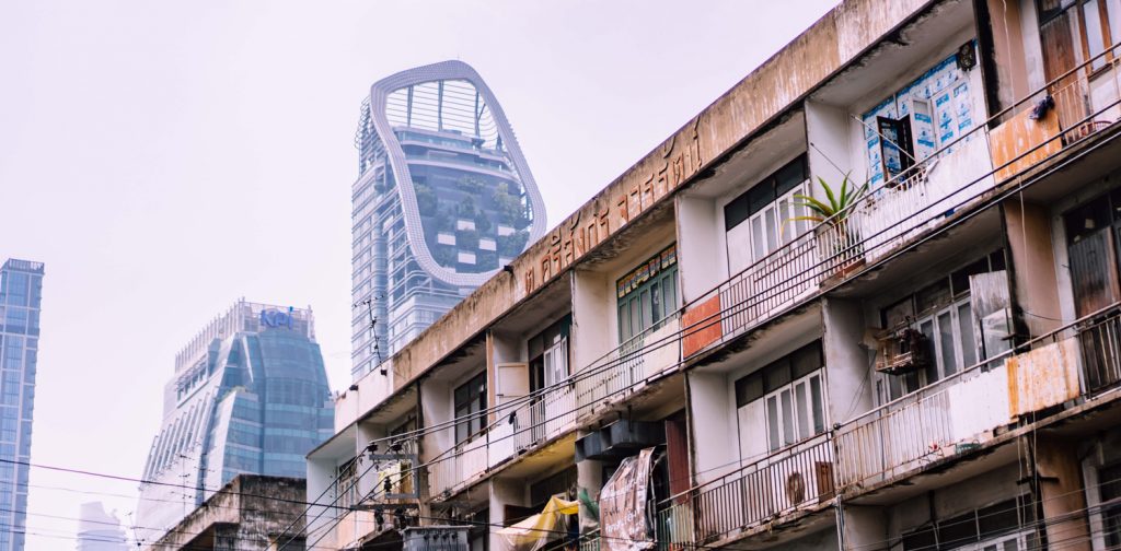 run-down housing with skyscrapers in the background