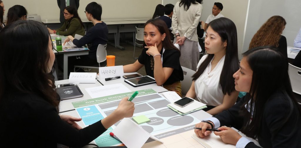 young delegates discussing in groups on several tables at Y20 Japan Summit 2019