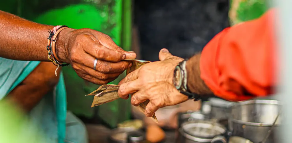 two hands are exchanging money to one another