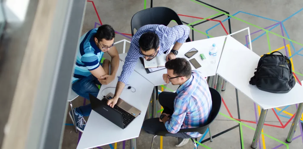 an aerial shot of three men in the middle of a discussion