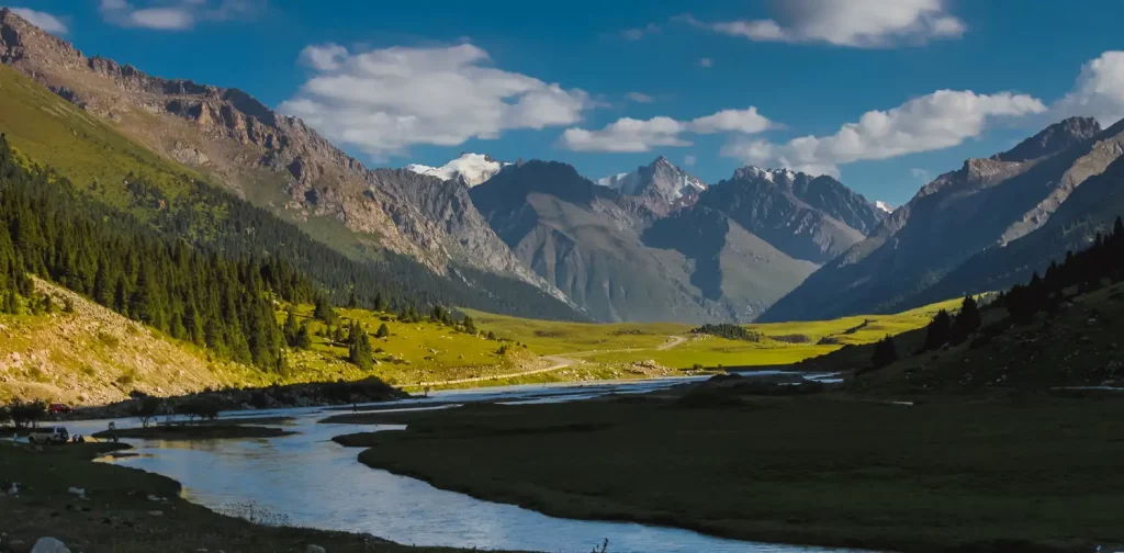 a mountain landscape showing a small river with several mountains as the background