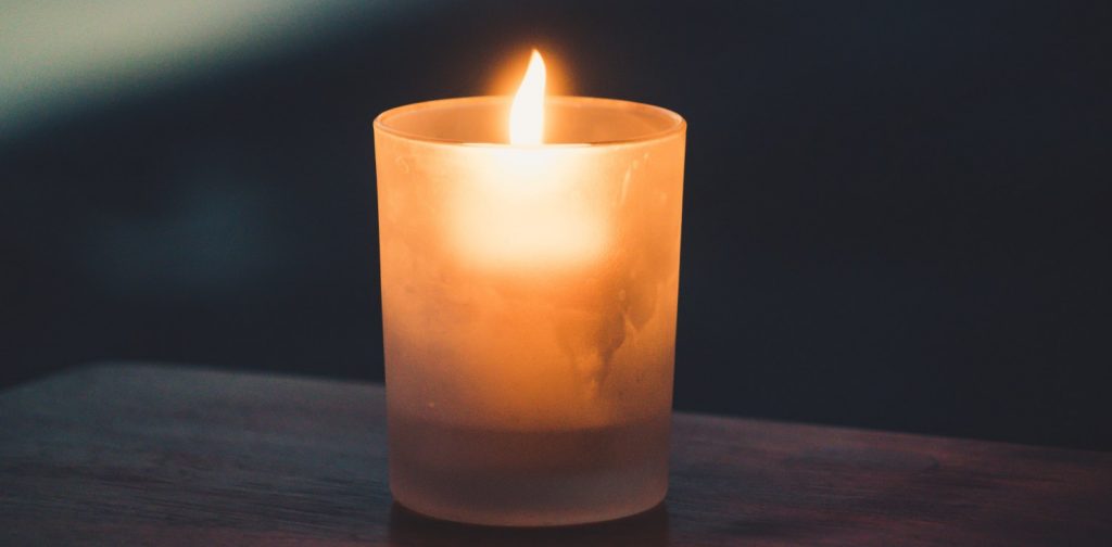 a candle light in the middle of a dark surrounding